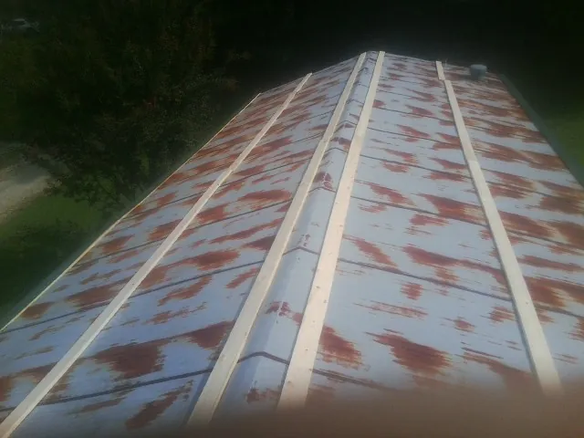 Rusted metal roof panels with new wood purlins before replacement — Storm Damage Roof Repair in Cashton by Roofing Brothers