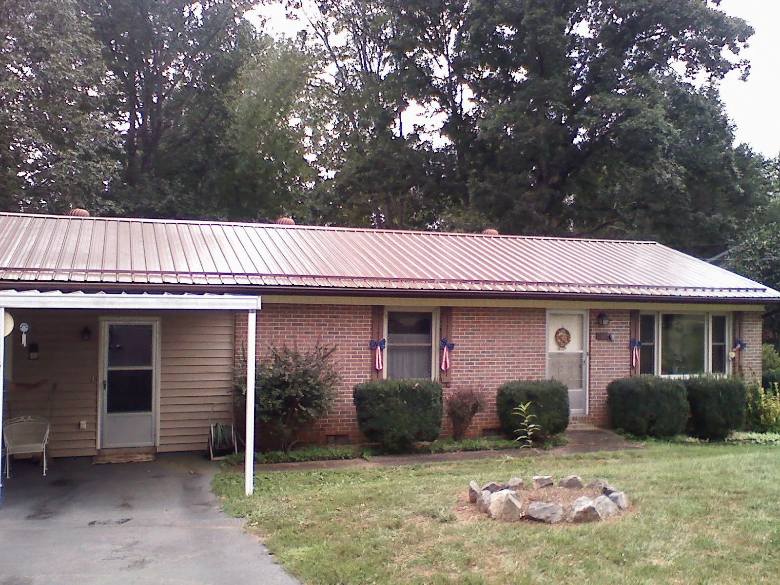 Bronze metal roof and carport on a brick ranch home — Roof Repair work by our crew in Cashton